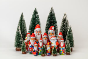Various chocolate nicholas stand in the midst of miniature Christmas trees, white background, icon image, Christmas time, Various chocolate nicholas stand in the midst of miniature Christmas trees, white background, icon image, Christmas time,